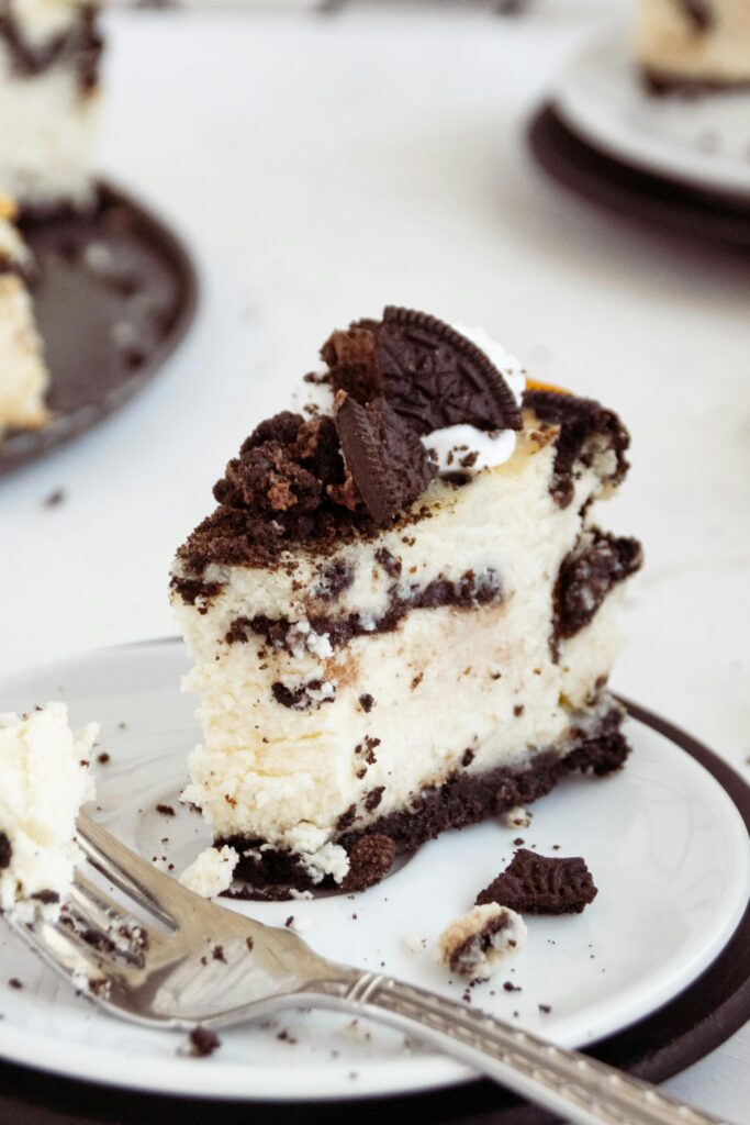 Sliced no-bake Oreo cheesecake with mini Oreos on top, ready to serve