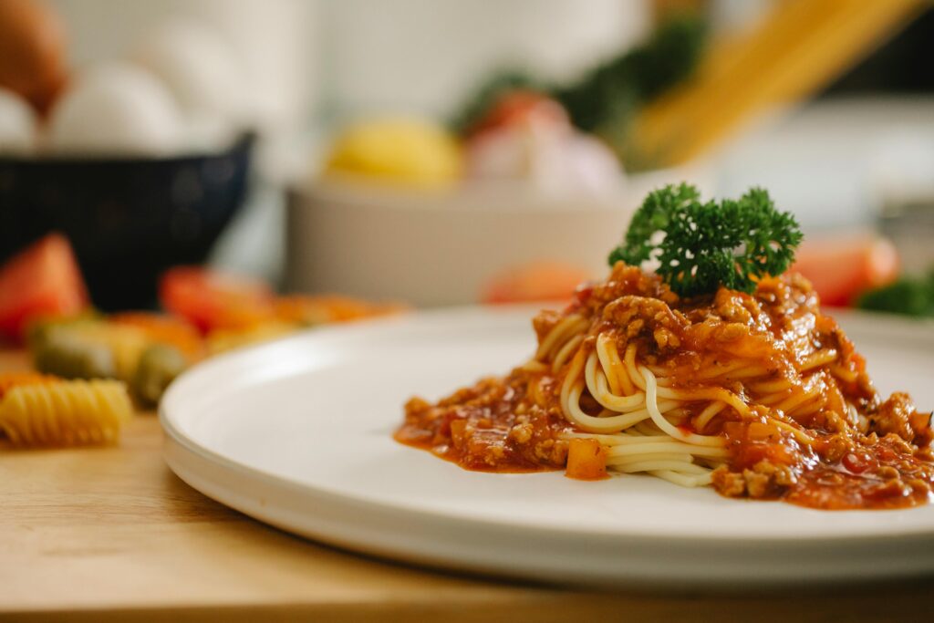 Classic Spaghetti Bolognese topped with fresh basil and grated Parmesan cheese, served on a white plate